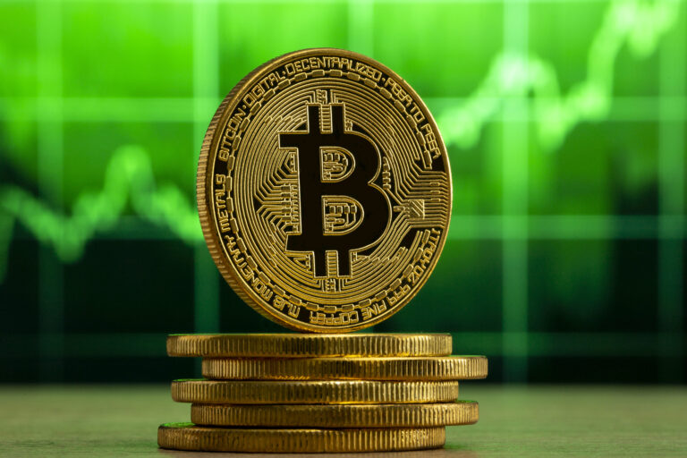 physical-bitcoin-standing-wood-table-front-green-graph-bitcoin-bull-market-concept